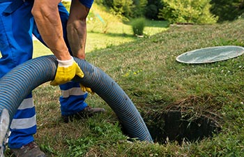 worker pumping household septic tank