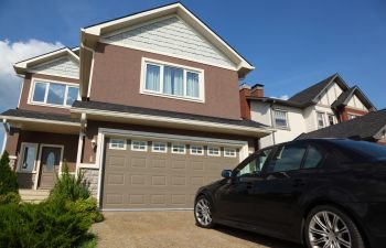 A car parked on a driveway of a residential house.